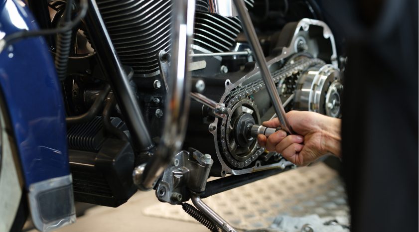 Técnico ajustando el sistema de transmisión de una motocicleta en taller de Kasei Motors